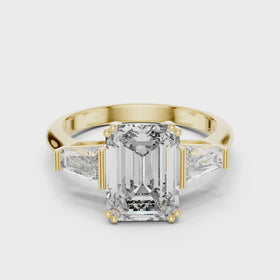 The Clara emerald-cut lab-grown diamond engagement ring with baguette side stones in yellow gold — rotating view